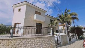 Biały dom z balkonem i palmą w obiekcie STAY Tranquility Cove w Larnace