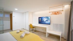 a room with a desk and a tv on the wall at Jable 6 - Waterfront Luxury Apartment in Corralejo