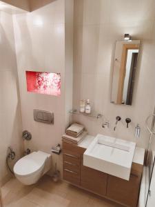 ein Badezimmer mit einem weißen Waschbecken und einem WC in der Unterkunft Luxury apartment in the heart of the capital in Kiew