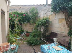 een kleine tuin met een tafel en een bank bij Maison familiale en centre-ville in Rochefort