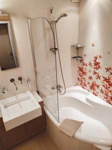 ein Badezimmer mit einer Dusche, einer Badewanne und einem Waschbecken in der Unterkunft Luxury apartment in the heart of the capital in Kiew