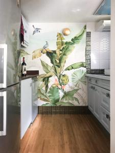 uma cozinha com um mural tropical na parede em Le Cabanon de Monte-Carlo avec Jardin Privé em Monte Carlo