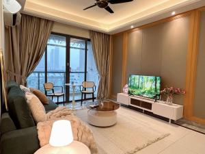 een woonkamer met een bank en een tv bij 3BR 6 pax RnF StylishFrench in Johor Bahru