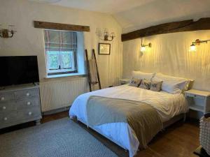 Giường trong phòng chung tại Charming 17th century cottage near Bakewell