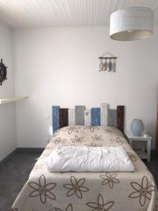 ein Schlafzimmer mit einem Bett mit einer Bettdecke darauf in der Unterkunft Charmante Maison, terrasse vue mer in Les Sables-dʼOlonne