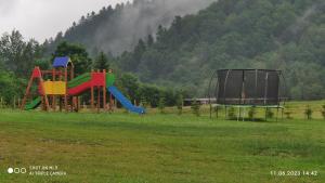 un parque infantil en un campo con tobogán en Biesiedlisko Bieszczadzkie, en Polańczyk