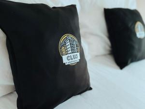 uma almofada preta com um logótipo de gillett numa cama em Cluj ApartHotel - VIVA CITY - em Cluj-Napoca