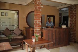 un hombre está parado en un mostrador en una habitación en D'Gilian Bungalow, en Gili Trawangan 60 fotos más
