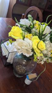 un jarrón lleno de flores amarillas y blancas en una mesa en Kinyanjui's Homes 001 with WiFi, en Morogoro