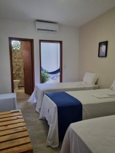 a hotel room with two beds and a window at Pousada Prazeres do Velho Chico 