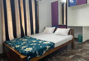 een bed met een blauwe en witte deken erop bij Meenus Home Stay in Anachal