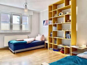 ein Schlafzimmer mit 2 Betten und einem Bücherregal in der Unterkunft Apartment Avanzato in Erfurt