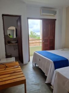 a bedroom with two beds and a large window at Pousada Prazeres do Velho Chico 