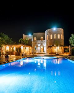 a large swimming pool in front of a building at night at RIAD YANITRI in Essaouira