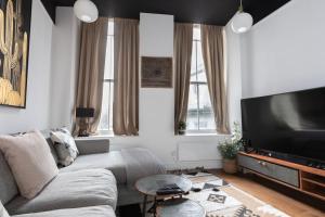 uma sala de estar com um sofá e uma televisão de ecrã plano em Superb 1 Bedroom Apartment Holborn London em Londres