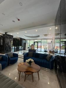 uma sala de estar com sofás azuis e uma mesa em Deluxe Studio Apartments at Kass Towers Accra - Upper Floor By VP Properties em Acra