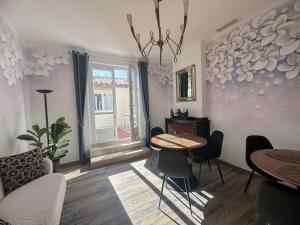 a living room with a table and chairs and a window at Face Cité - Chambres D'Hôtes - Parking & Garage Gratuit - Wi-Fi Gratuit in Carcassonne