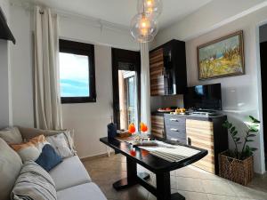 a living room with a couch and a table at Casa Portokali Chalkidiki - Modern Comfort with Authentic Greek Charm in Nea Potidaea