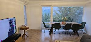 sala de estar con mesa, sillas y ventana grande en Wohnung im Schwarzwald mit Panorama Blick en Kleines Wiesental