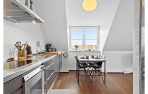 a kitchen with a table and a small table with chairs at Gorgeous Apartment In Skagen With Sauna in Skagen