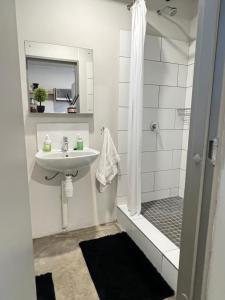 a white bathroom with a sink and a shower at The onyx in Johannesburg