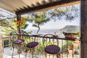 einen Balkon mit Stühlen und Meerblick in der Unterkunft Maison exceptionnelle in Roquebrune-Cap-Martin