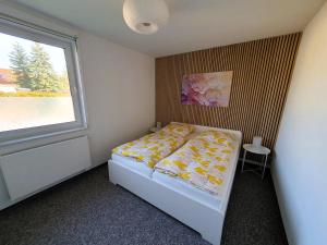 um pequeno quarto com uma cama e uma janela em Ferienhaus Winkler - FeWo Nordland - KEINE MONTEURE em Schwerin