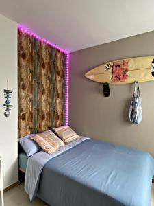 Zimmer mit einem Bett und einem Surfbrett an der Wand in der Unterkunft Amanecer Isleño Habitaciones in Arrecife