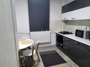 eine kleine Küche mit einem Tisch und einer Mikrowelle in der Unterkunft Cozy Apartment Central II in Bacău