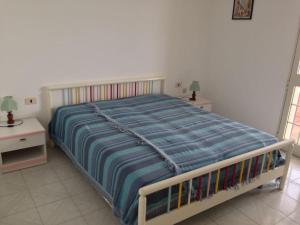 a large bed in a bedroom with two night stands at Leukos in Leuca
