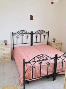 a bedroom with a black bed with a pink bedspread at Leukos in Leuca
