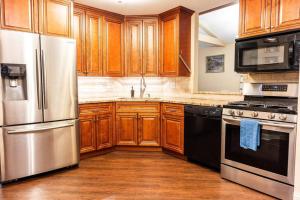 a kitchen with wooden cabinets and stainless steel appliances at High-End Oasis Close to Fun in Homewood