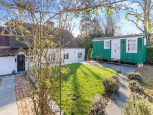 a garden with a caravan and a house at Malting Cottage 