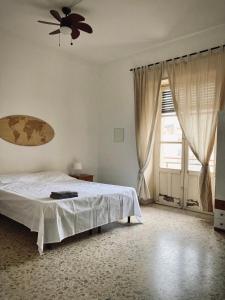 Un dormitorio con una cama y un ventilador de techo. en Shared apartment in Catania center., en Catania