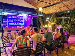 un grupo de personas sentadas en una mesa en un restaurante en Charming Pool Twin Holiday Home, en Patong Beach