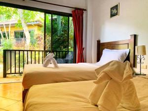 Dos camas en una habitación con una gran ventana. en Charming Pool Twin Holiday Home, en Patong Beach 28 fotos más