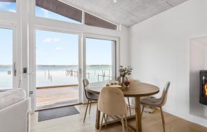 a dining room with a table and a view of the ocean at 1 Bedroom Amazing Home In Munkebo in Munkebo