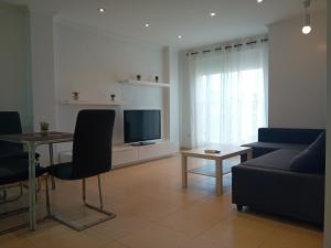sala de estar con sofá, mesa y TV en Apartamento Luna, en Gandía