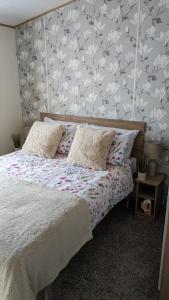 a bedroom with a bed with a floral wallpaper at Floppyfeet Pet Friendly Holiday Home Rental Thornwick Bay, Flamborough in Flamborough