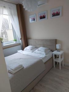 1 dormitorio con cama blanca y ventana en come&stay Zielona Góra, en Zielona Góra