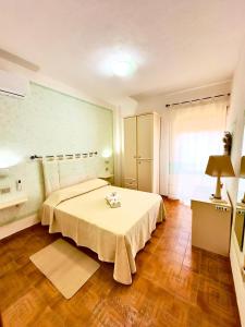 een slaapkamer met een bed en een tafel. bij Hotel Mediterraneo in Costa Paradiso