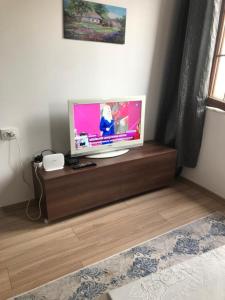 a flat screen tv sitting on a wooden stand in a room at Aymena B in Kuşadası