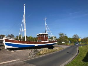 a boat sitting on the side of a road at Ferienkate Norddeich in Norddeich