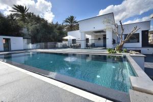 a swimming pool in front of a house at וילה אליה in Migdal