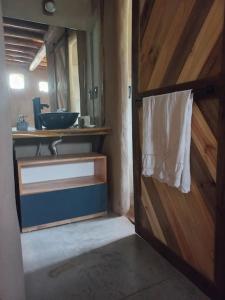 ein Badezimmer mit einer Holztür und einem Waschbecken in der Unterkunft Hermosa casa amplia y luminosa in Villa Los Aromos