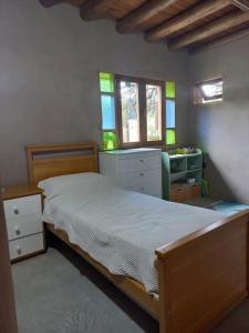 ein Schlafzimmer mit einem Bett, einem Schreibtisch und Fenstern in der Unterkunft Hermosa casa amplia y luminosa in Villa Los Aromos