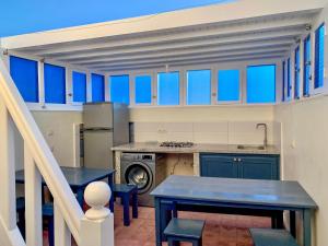 a kitchen with blue cabinets and a table and chairs at La Maison du Belvédère in Essaouira