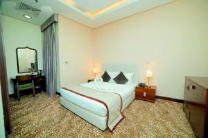 a hotel room with a large bed and a mirror at GREEN GARDEN HOTEL in Doha