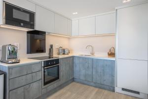 a kitchen with white cabinets and stainless steel appliances at Polzeath Beach House in Polzeath