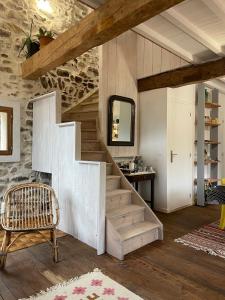 a staircase in a room with a chair and a mirror at Cozy Catalan Cottage in Reynès